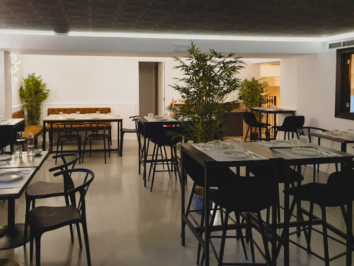 interior de un restuarante con varias mesas preparadas para comer